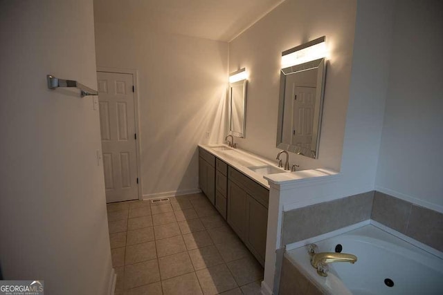 bathroom featuring vanity, tile patterned floors, and tiled tub