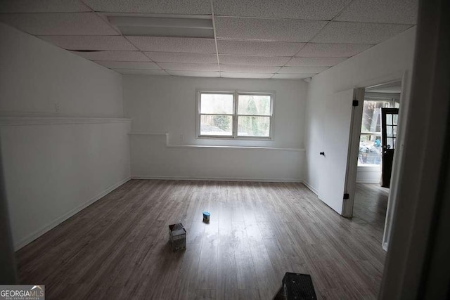 spare room featuring hardwood / wood-style flooring and a drop ceiling