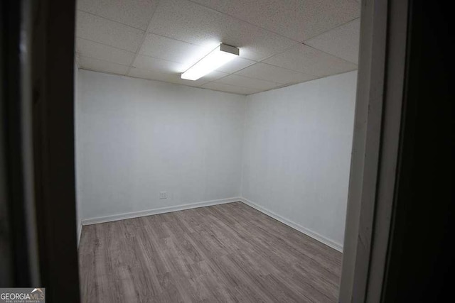 empty room with light hardwood / wood-style floors and a drop ceiling