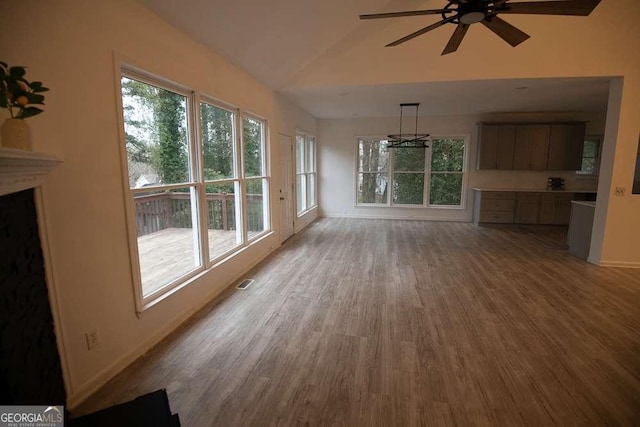 unfurnished living room featuring ceiling fan, light hardwood / wood-style flooring, and vaulted ceiling