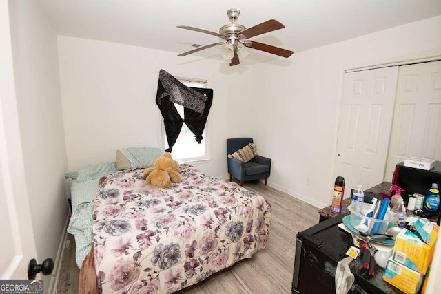 bedroom featuring ceiling fan, light wood-type flooring, and a closet