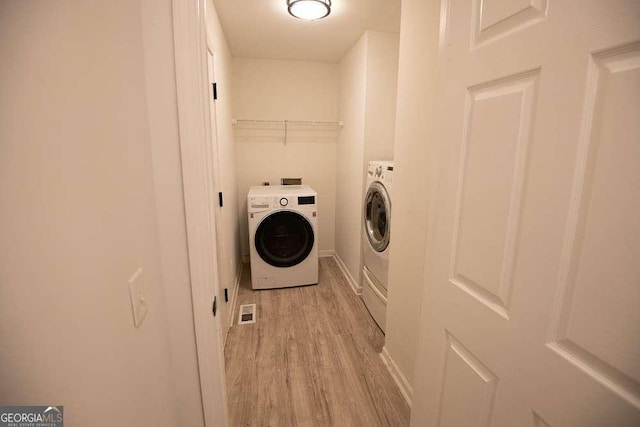 laundry room with light hardwood / wood-style flooring and independent washer and dryer