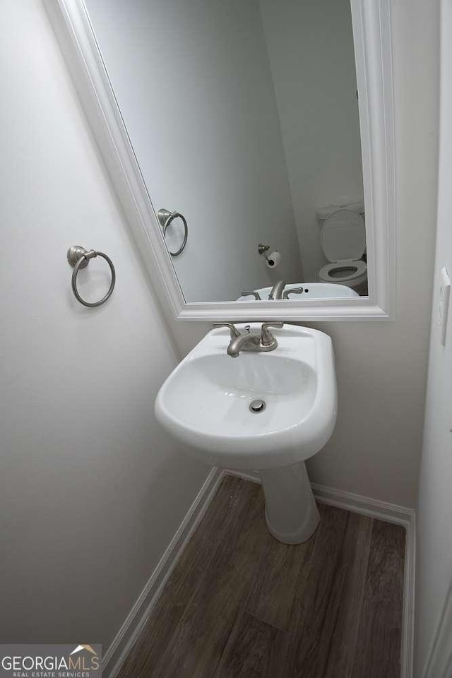 bathroom with hardwood / wood-style floors and toilet