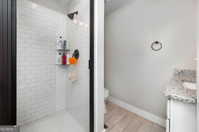 bathroom with a shower with shower door, vanity, and toilet