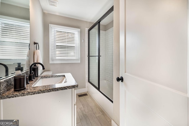 bathroom featuring vanity and bath / shower combo with glass door