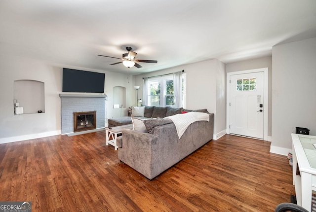 living room with ceiling fan, dark wood-type flooring, and a fireplace