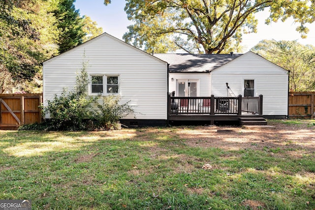 rear view of property with a lawn and a wooden deck