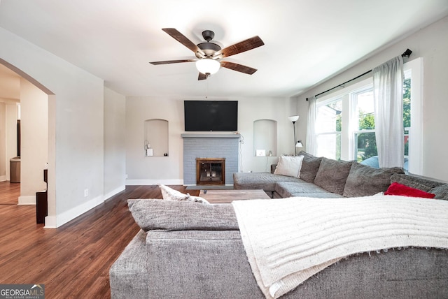 living room featuring a fireplace, ceiling fan, and dark hardwood / wood-style floors