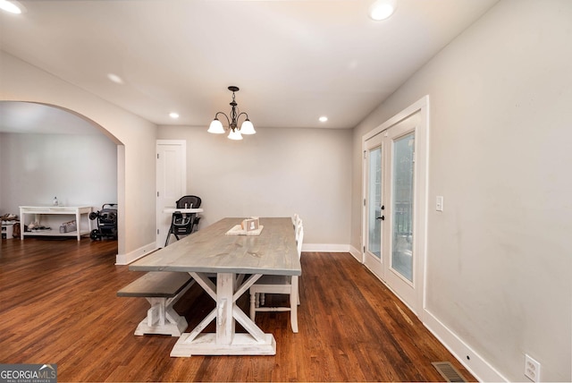 dining room featuring dark wood-type flooring, french doors, and an inviting chandelier