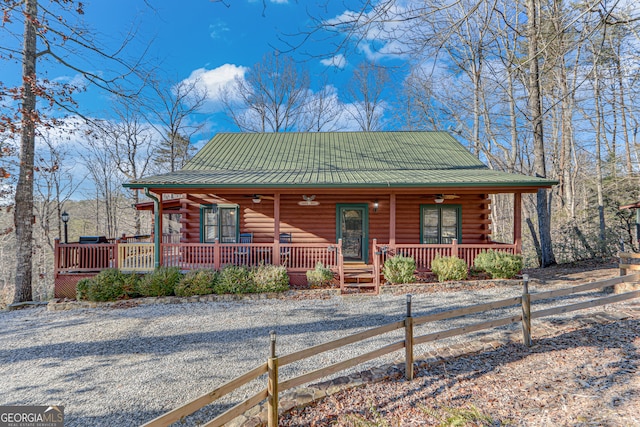 log cabin featuring ceiling fan and covered porch