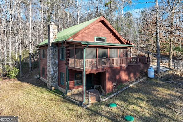 back of house with a lawn and a sunroom