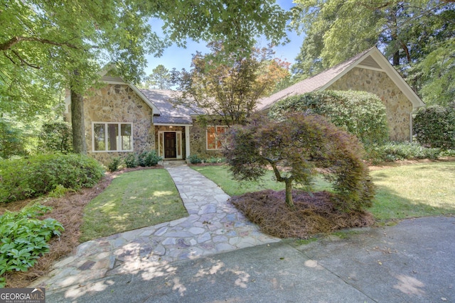 view of front of home with stone siding and a front yard