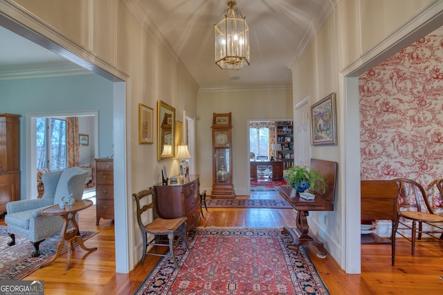 entrance foyer with ornamental molding, hardwood / wood-style floors, and a healthy amount of sunlight