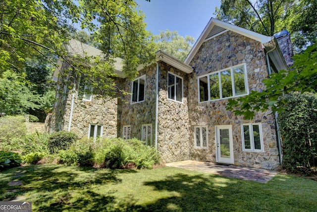 back of property with a lawn and a patio area