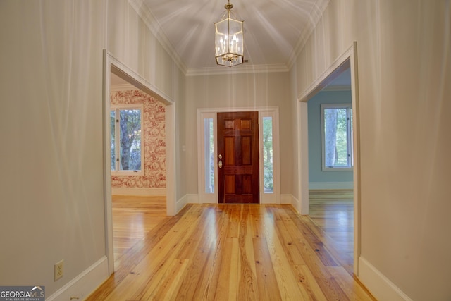 foyer with hardwood / wood-style flooring, baseboards, and an inviting chandelier