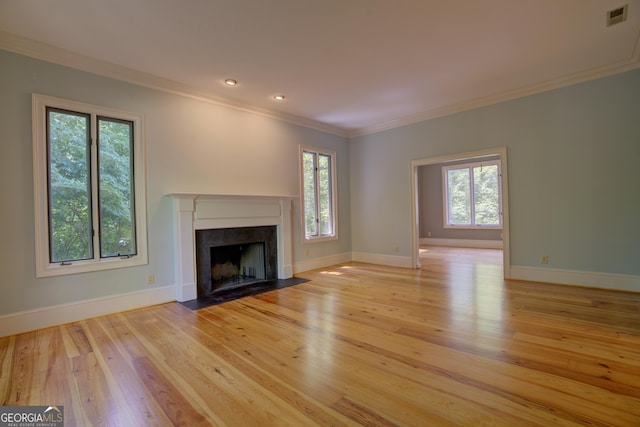 unfurnished living room featuring light wood-style flooring, a fireplace, visible vents, and ornamental molding