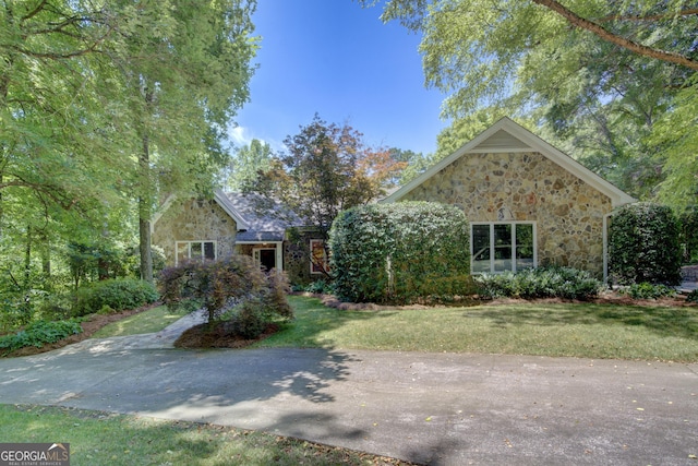 view of front facade featuring stone siding and a front yard