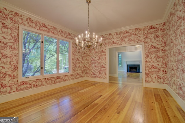 unfurnished dining area with wood-type flooring, a fireplace, baseboards, and wallpapered walls