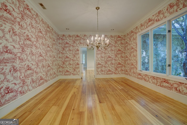 unfurnished dining area featuring wallpapered walls, baseboards, crown molding, light wood-type flooring, and a notable chandelier