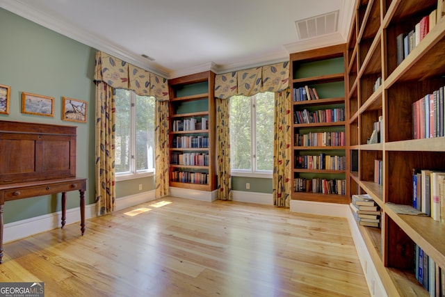 unfurnished room with ornamental molding, visible vents, plenty of natural light, and wood finished floors