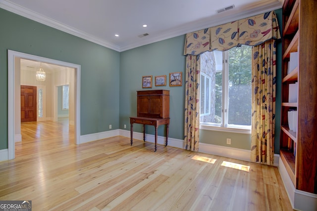 living area with wood-type flooring, visible vents, ornamental molding, and baseboards