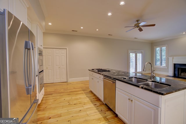 kitchen featuring appliances with stainless steel finishes, white cabinets, a sink, and open floor plan