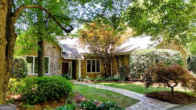 view of front of property featuring stone siding and a front yard