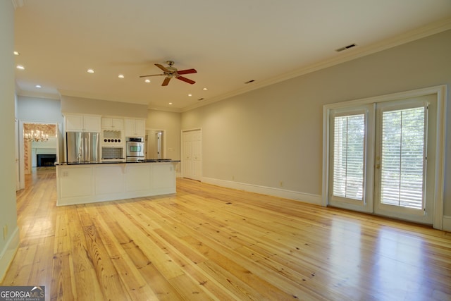 kitchen featuring light wood-style flooring, white cabinets, stainless steel refrigerator, dark countertops, and crown molding