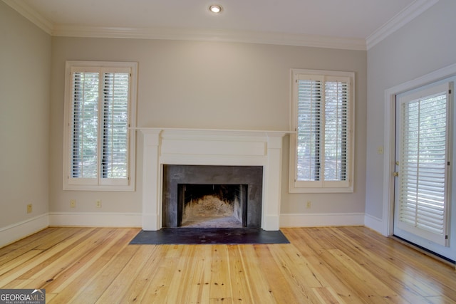 unfurnished living room with ornamental molding, hardwood / wood-style floors, a fireplace with flush hearth, and baseboards