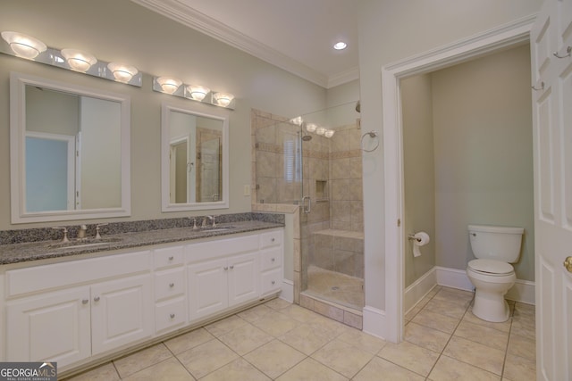 full bathroom featuring crown molding, a sink, toilet, and a shower stall