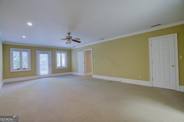 spare room featuring light colored carpet, crown molding, and visible vents