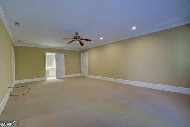 spare room featuring light colored carpet, visible vents, crown molding, and baseboards