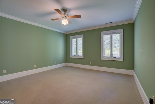 unfurnished room with ceiling fan, light carpet, visible vents, baseboards, and crown molding