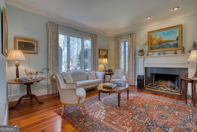 living room featuring baseboards, a fireplace with flush hearth, wood finished floors, crown molding, and recessed lighting