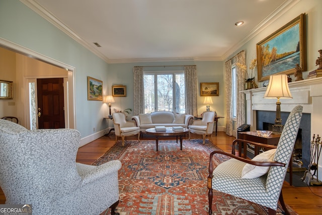 living area with ornamental molding, baseboards, a fireplace with flush hearth, and wood finished floors