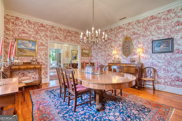 dining room featuring wallpapered walls, visible vents, baseboards, ornamental molding, and hardwood / wood-style floors