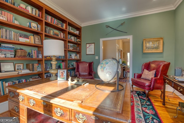 office space with ornamental molding, built in shelves, and wood finished floors