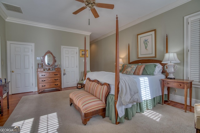 bedroom featuring baseboards, visible vents, a ceiling fan, ornamental molding, and wood finished floors