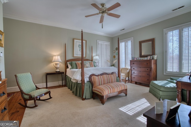 bedroom with baseboards, visible vents, crown molding, and wood finished floors