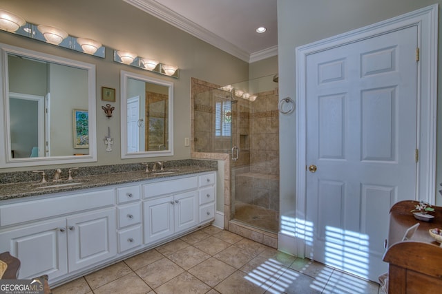 bathroom with double vanity, a stall shower, crown molding, and a sink