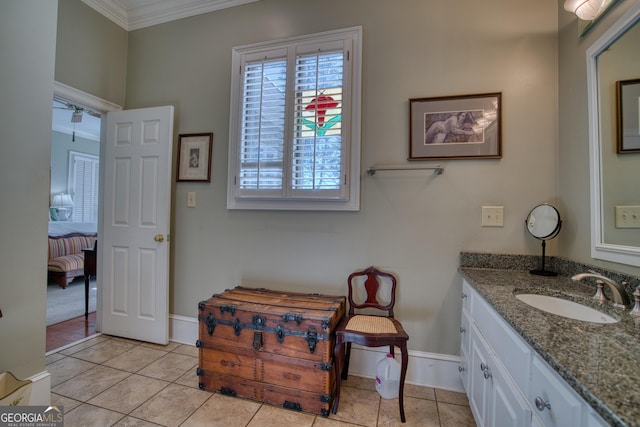 bathroom featuring tile patterned floors, baseboards, ornamental molding, and vanity