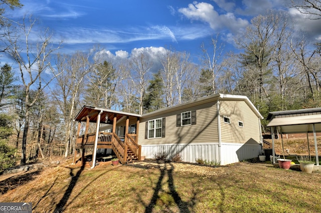 manufactured / mobile home featuring a wooden deck and a front lawn