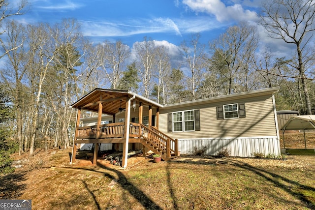 view of front of property featuring a front yard, a carport, and ceiling fan