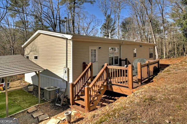 rear view of house with central AC and a wooden deck