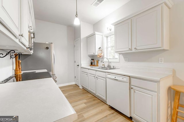 kitchen with white dishwasher, sink, pendant lighting, white cabinets, and light hardwood / wood-style floors