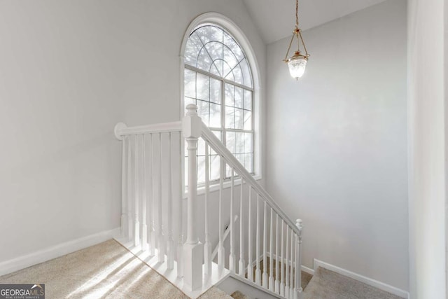 staircase with carpet and vaulted ceiling