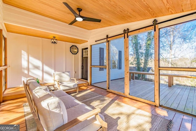 unfurnished sunroom with ceiling fan, wood ceiling, and lofted ceiling