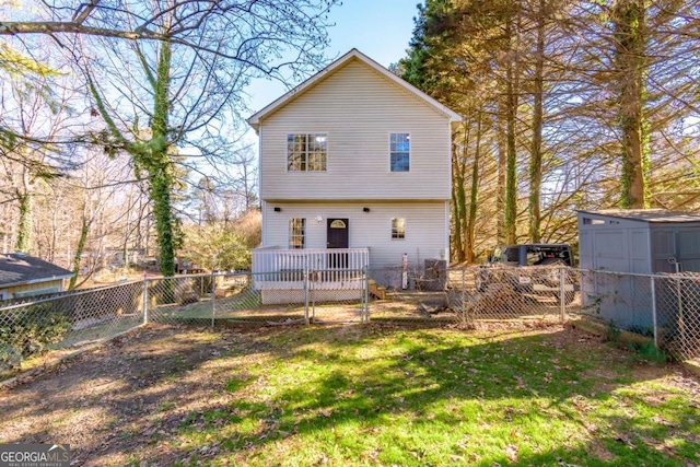 back of house with a yard and a storage shed