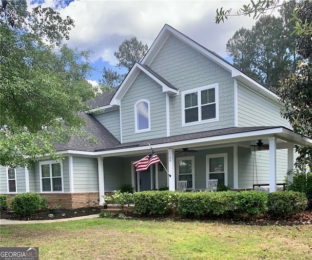 view of front of house featuring ceiling fan, covered porch, and a front lawn