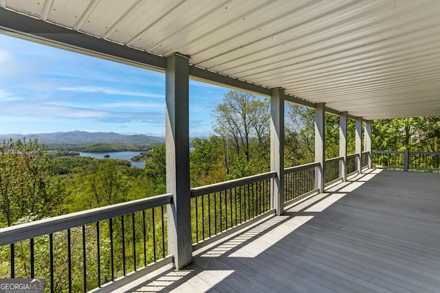 wooden deck with a water and mountain view